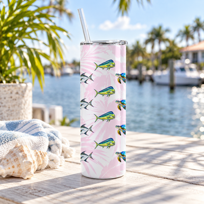 Stainless steel tumbler with pink palm leaves, colorful fish, and sea turtles, shown beside the water.