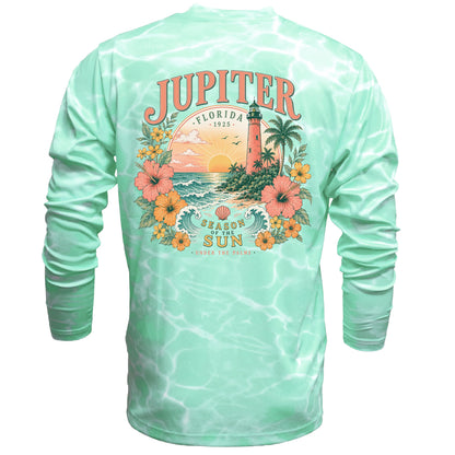 A mint green long-sleeve t-shirt with a white tie-dye pattern, featuring a large back graphic of a Florida sunset scene with a lighthouse, palm trees, and the text 'JUPITER FLORIDA 1923' and 'SEASON OF THE SUN'.